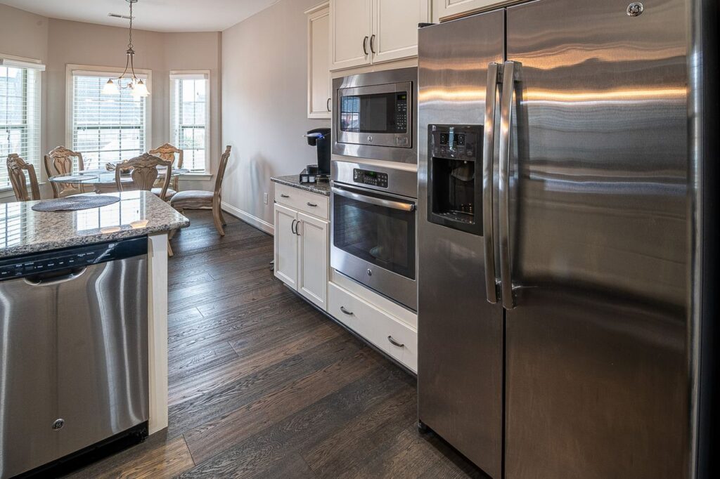 Spacious modern kitchen featuring stainless steel appliances and a dining area.