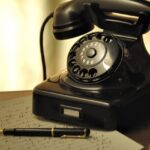 A nostalgic scene with an antique rotary phone and a fountain pen on a desk.